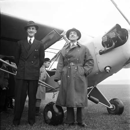 Yngve Ligner t.h. i rock har just flugit hem klubbens första Piper Cub SE-ATE den 27 april 1946. Foto: Åke Ahlstrand, Specialfoto