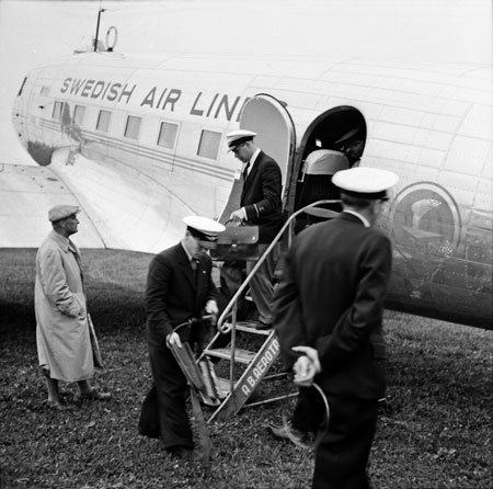 Markpersonal grejar. Flygvärden är på väg ut medan telegrafisten anas bakom i dörren. Foto: Åke Ahlstrand, Specialfoto