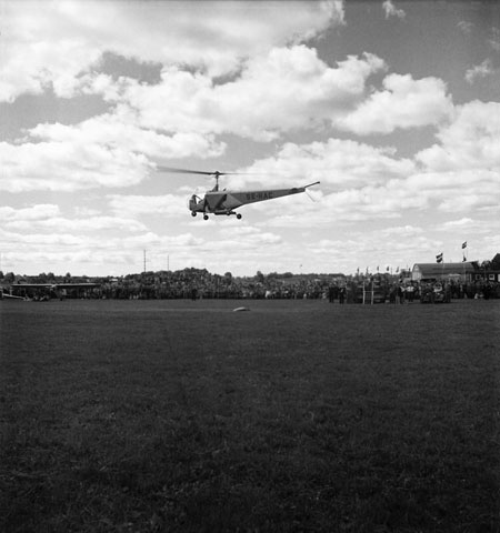 Helikoptern, publiken, hangaren och speakerns podium. Foto: Åke Ahlstrand, Specialfoto