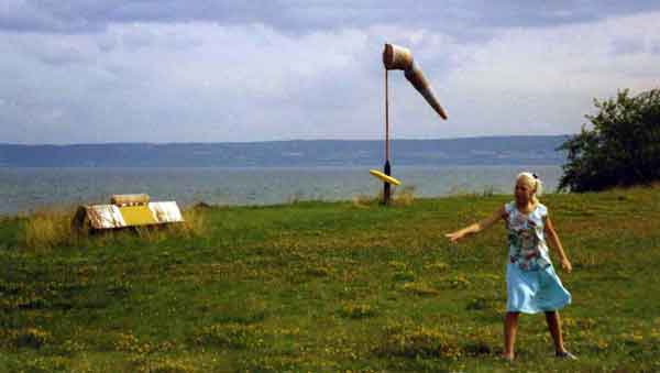 Vår dotter Monika kastar flygande tefat i motvind vid stranden.