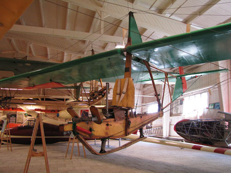 Schulgleiter SG-38 i Ållebergs segelflygmuseum, en standardglidare för grundläggande utbildning. Bakom t.v. skymtar en mörkröd Weihe och en vit Olympia. Foto: Rolf Broberg 2015