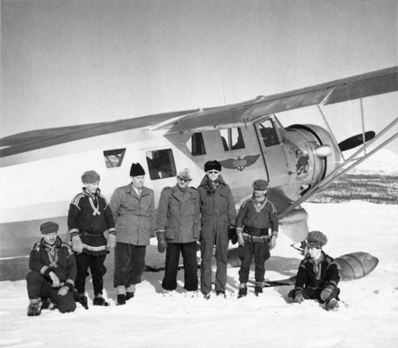 Jean Karlsson i svart skinnmössa vid Aros-Flygmärket. Nr 3 fr.v. i hög svart mössa är lappfogde Olov Andersson. Foto: Tore Jonsing