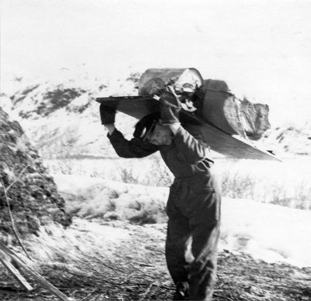 Jean Karlsson kånkar ved och tunna. Foto: Tore Jonsing