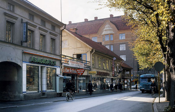 Ungefär samma vy på 1960-talet. Gullbergs butik har hunnit bli AB A Gustafsons chark. – Det välkända "Nya konditoriet" låg i det gula trähuset och hade servering på takterrassen. – Bildkälla: Örebro stadsarkiv, fotograf okänd, bildnummer SBK-SD-0068.