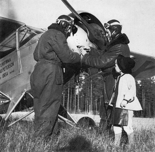 Flyglärare Tore Strindberg t.h. förklarar någon detalj på Hans Petersons – GV-38 SE-AHX för sin elev och en intresserad liten mas. – Flygplatsen är troligen Orsa Tallhed. Foto i FM 4/1982