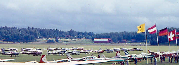 Hjortsbergstorpsgläntan med Hjortsbergstorps byggnader på höger sida. Detalj ur bild från det internationella flygrallyt lördag den 21 juli 1965. Foto: okänd via SFF Örebro.