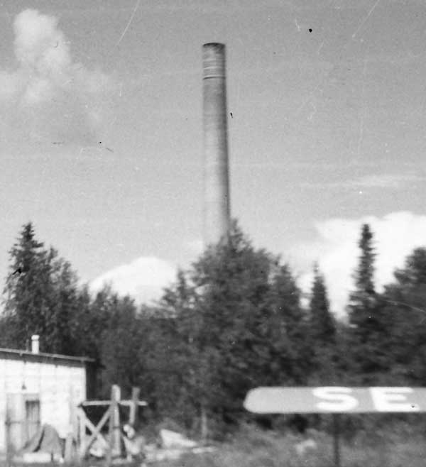 Detalj: Skorstenen bakom Fisk-Flyg L&L:s flyghamn. Foto: Arne Tengler 1948.