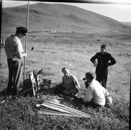 Mobil radiostation med telefonlur på fjället. Mannen t.h. har Norrlandsflygs emblem i uniformen. Foto: Arne Tengler